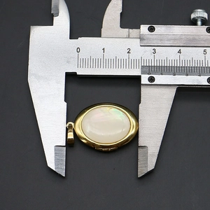 Détail d'un pendentif ovale en nacre avec opale mesurant 2,5 cm par pied à coulisse