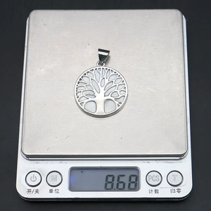 Detailed view of Tree of Life shell pendant on digital scale showing 8.68g weight