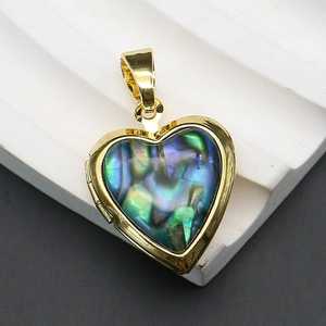 Vista macro di un medaglione a cuore placcato oro con intarsio in abalone cangiante