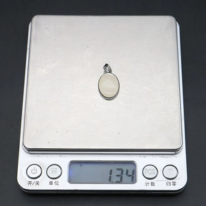 Detailansicht eines 1,34g Muschelperlenanhängers auf einer elektronischen Waage