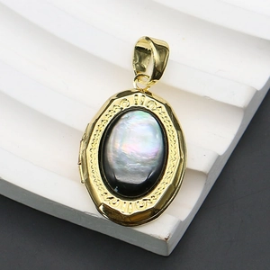 Macro shot of oval gold locket with iridescent abalone shell inlay and vintage carvings