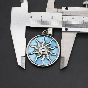 Detail view of a 30mm sun totem pendant with blue shell inlay and silver metal frame