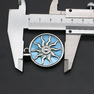 Measuring tool showing 3.3cm diameter of blue shell sun totem pendant with silver base