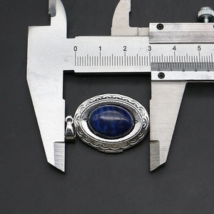Detailed macro view showing the width measurement of the locket pendant with a digital caliper
