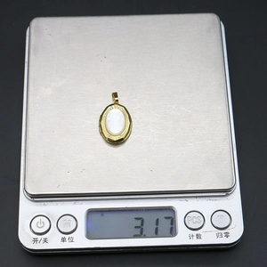 Vue détaillée d'un pendentif ovale en nacre pesant 3,17 g sur une balance électronique