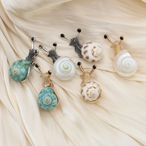Elegant snail shell brooches with natural pearl textures and crystal metal accents