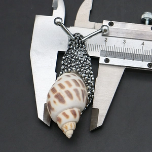Detailed macro of a snail brooch with sea shell, measuring 4cm on a digital caliper tool