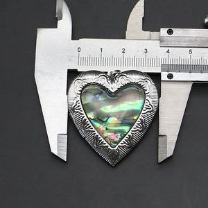 Vista dettagliata del medaglione a cuore in conchiglia abalone con misura di 3,7 cm