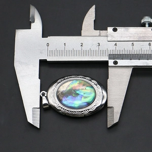Detaillierte Makroansicht zur Messung der 3,2 cm Breite des ovalen Abalone-Muschel-Anhängers