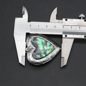 Ciondolo a cuore in conchiglia di abalone misurato con calibro che mostra larghezza 38mm