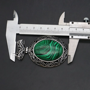 Macro view of green malachite oval pendant with ornate silver filigree frame measuring 50mm