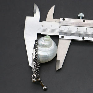 Macro shot of snail pendant measuring 20mm width with a digital caliper tool