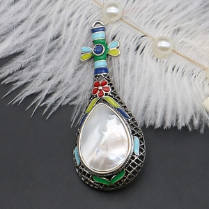 Detail der Pipa-Brosche mit bunter Emaille und weißer Perlmutt-Einlage im Ethno-Stil