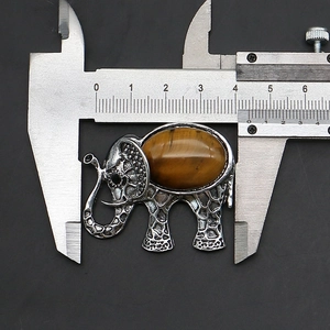 Macro detail of elephant brooch showing tiger eye stone inlay and 40mm caliper measurement