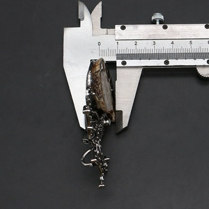 Measuring thickness of antique silver octopus shell brooch pendant with a metal caliper