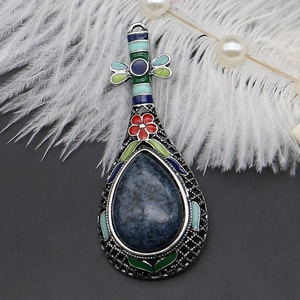 Detailaufnahme der ethnischen Pipa-Brosche mit blauem birnenförmigem Stein und Emaille