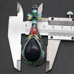 Pendentif luth en turquoise mesuré avec un pied à coulisse montrant 27mm de large
