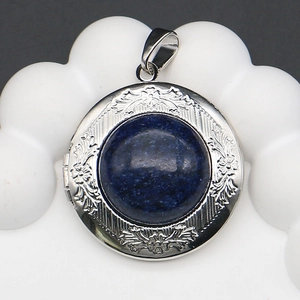 Macro shot of silver locket pendant with round blue lapis stone and engraved details