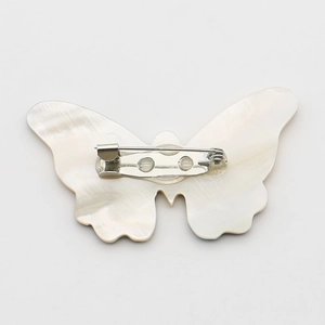 Natural shell butterfly brooch pin with iridescent shell texture and silver safety pin back