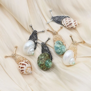 Handcrafted snail shell brooches in gold and silver plating with natural seashell inlay