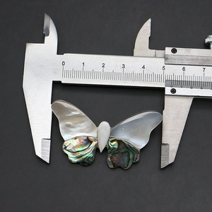 Detailed macro view showing a butterfly brooch width measurement of 5.5cm with a caliper