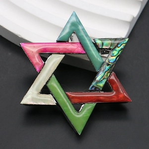Gedetailleerde macro-opname van de vintage hexagram broche met kleurrijke abalone schelp