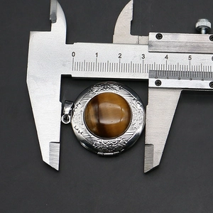 Macro view showing 32mm diameter measurement of tiger eye stone pendant with floral metal frame