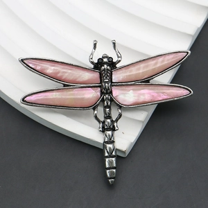 Detailed macro view of retro silver dragonfly brooch with pink abalone shell inlay