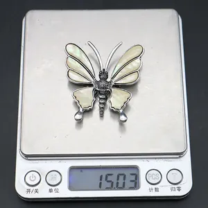 Zinc alloy butterfly pendant on electronic scale showing weight of 15.03 grams
