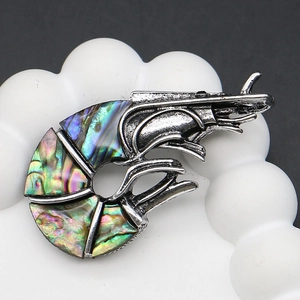 Macro view of vintage silver prawn brooch with iridescent abalone shell inlay detail