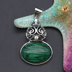 Macro shot of malachite stone pendant with hollow silver filigree and small diamond