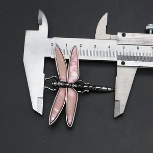 Macro shot measuring vintage dragonfly brooch with pink shell wings at 4.5 cm width