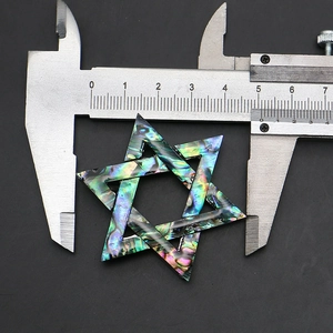 Detalle macro de broche hexagrama de concha abalón medido con un calibrador de precisión