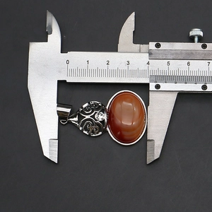 Macro view of vintage oval stone pendant showing precise 4cm length measurement