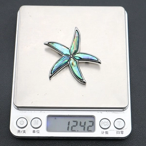 Macro shot showing 12.42g weight of starfish shell pendant on a digital scale