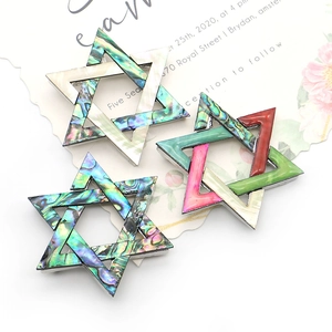 Vintage hexagram broches met kleurrijke abalone schelpen en metalen frame op kaart