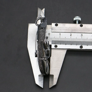 Macro side view of a vintage zinc alloy pendant showing thickness measurement with calipers