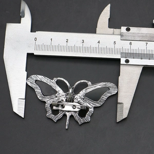 Detailed macro view of the butterfly brooch back showing the pin closure and size measurement