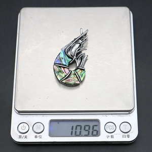 Macro detail of a 10.96g shrimp pendant brooch featuring natural colorful abalone shell