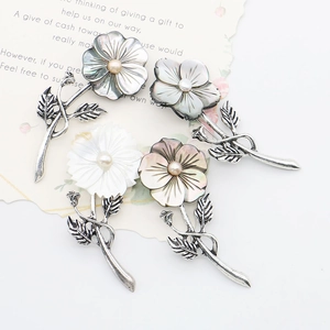 Set of four natural black shell flower brooches with pearl centers and silver leaves