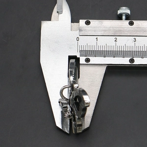 Macro shot of vernier caliper measuring the 5mm thickness of the silver butterfly pendant