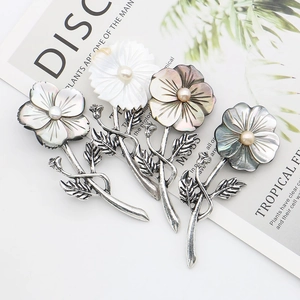 Handcrafted natural black shell flower brooches with central pearls and silver accents