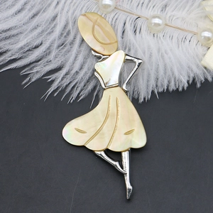 Macro shot of silver lady profile brooch with yellow shell texture on feathers