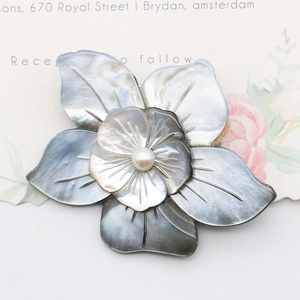 Elegant flower shell brooch with iridescent grey petals and a central white pearl ornament