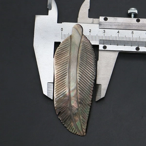 Detail showing natural black mother of pearl feather pendant width measurement with caliper