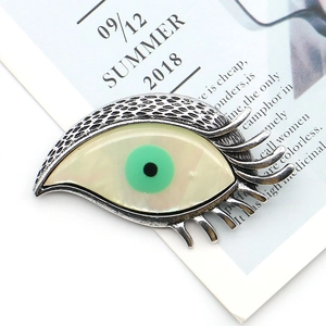 Broche œil vintage en métal argenté avec iris vert et texture nacrée scintillante
