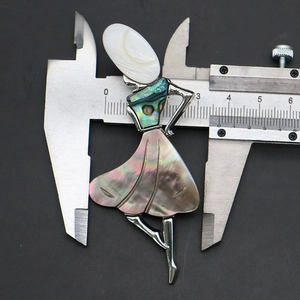 Detailed measurement of ballerina brooch with abalone shell inlays using a caliper