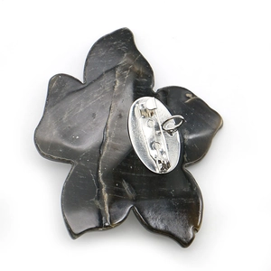 Leaf-shaped black shell brooch and pendant with silver pin back on white background