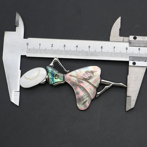 Macro shot showing retro shell dancer brooch measuring 8.5cm with a digital caliper