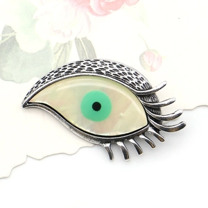 Broche œil grec en argent avec nacre blanche et pupille verte sur support de carte